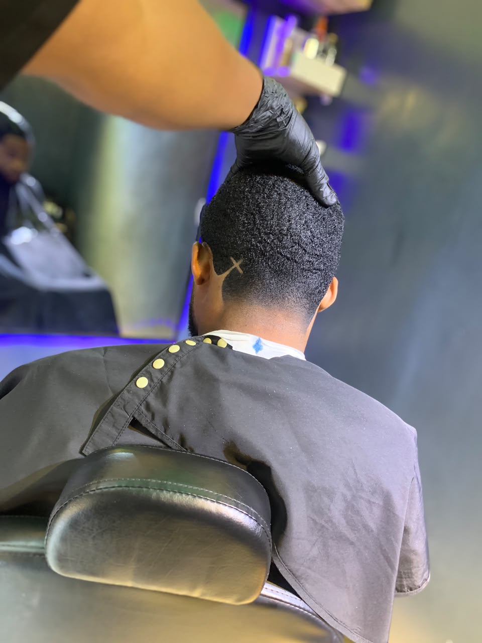Barber finishing the back of a tapered haircut